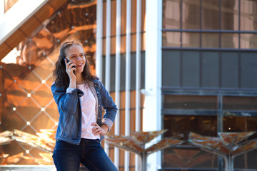 teen girl having a mobile phone talk in a large metropolis
