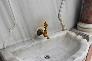 Turkish Ottoman style antique fountain water tap in view. Antique Turkish faucet on wall
