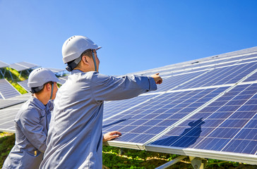 Two Asian engineers are testing the solar photovoltaic base at the top of the mountain