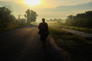 Buddhist monk walking on rural road