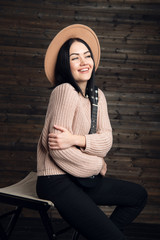 Pretty young woman hugging her guitar, dressed in country style