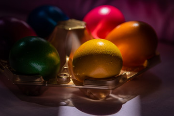 Colorful Easter eggs in basket on soft, plain background 