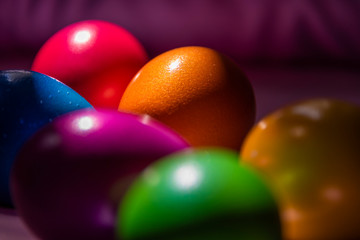 Colorful Easter eggs in basket on soft, plain background 