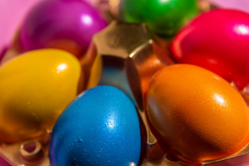 Colorful Easter eggs in basket on soft, plain background 