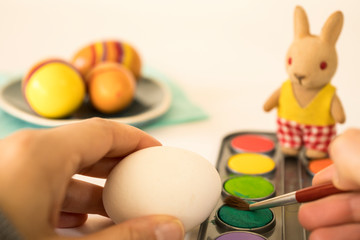 close up, painting  eggs with stuffed Easter bunny
