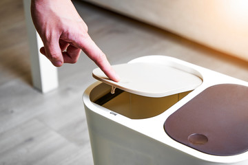 Press the trash can lid with your hand to pop up the lid