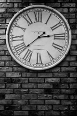 Vintage clock hanging on an old brick wall.With copy space