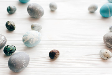 Stylish Easter eggs on white wooden background with space for text. Modern easter eggs painted with natural dye in blue and grey marble. Happy Easter, greeting card image