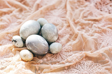 Fototapeta na wymiar Stylish Easter eggs on rustic fabric in sunny light on wood. Modern colorful eggs painted with natural dye in grey marble. Happy Easter, greeting card