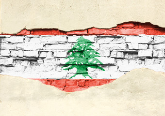 National flag of Lebanon on a brick background. Brick wall with partially destroyed plaster, background or texture.
