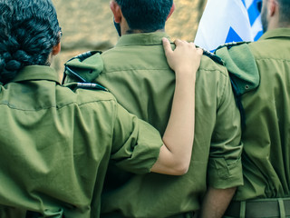 Israeli soldiers with flag of Israel on blurred background of Western Wall