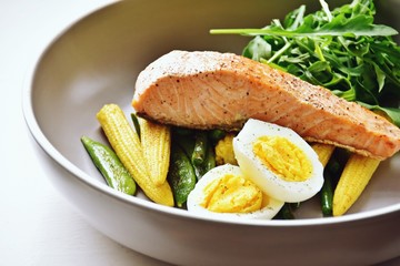 Roasted salmon with stir fry vegetables and egg isolated on white