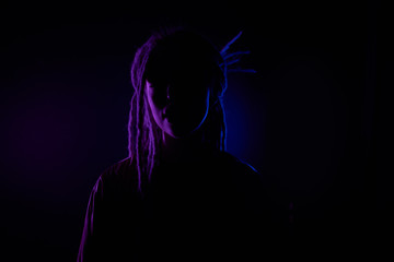 Fototapeta na wymiar beautiful girl in the light of neon colored lamps light blue purple contours, girl silhouette. on black background