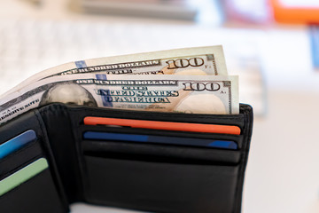 100 dollar bills in mans wallet with credit cards and online shopping