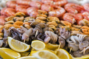 Appetizing skewers of seafoods closeup.