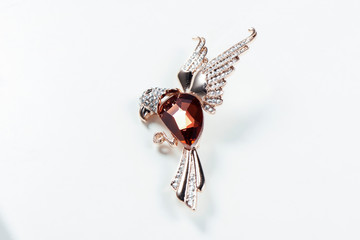 Bird-shaped brooch on white background