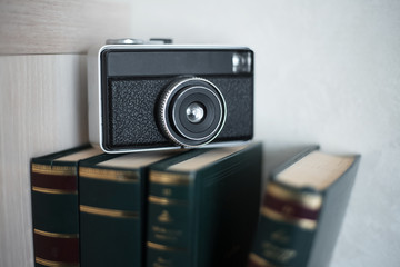 Books and vintage camera over white background.