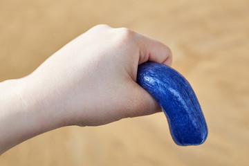 A toy made of plasticine in the hand of a woman, the theme of sexual dysfunctions, the toy symbolizes the penis - obrazy, fototapety, plakaty