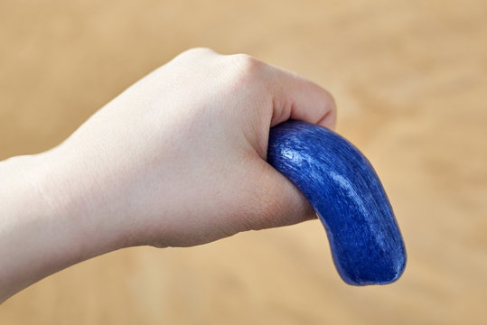 A toy made of plasticine in the hand of a woman, the theme of sexual dysfunctions, the toy symbolizes the penis