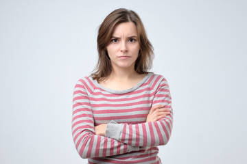 Young serious european woman portrait looking with irritation at camera.