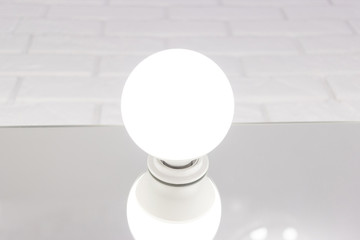 Beautiful stylish long hair curly blonde woman with bright hollywood makeup in dark blue shiny dress sitting on table near professional lighting mirror looking away with passion. indoor studio shot.