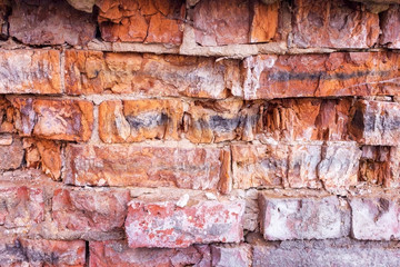 Red brick destroyed wall background. Old destroyed bricks, background and texture.