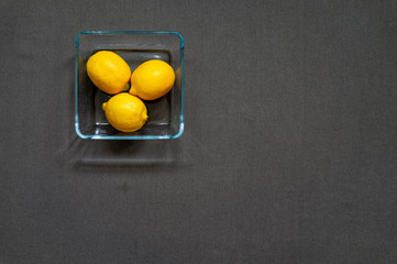 Fototapeta na wymiar Top view on the table set with yellow lemons and grey tablecloth