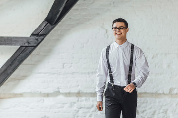 Thoughtful young businessman standing in modern office interior. Boss concept.