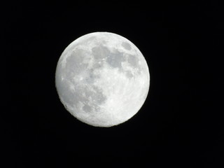 Genova, Italy - 03/20/2019: An amazing photography of the full moon over the city of Genova by night with a great clear sky in background and some stars
