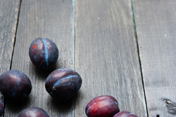plums on black wooden table