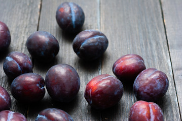 plums on black wooden table