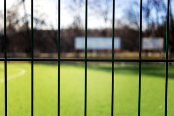 lawn field for playing minifootball behind the green fence mesh