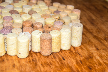 many old wine corks stand on wooden background side