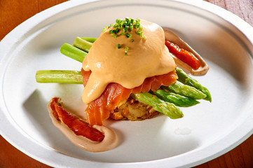 fried egg with bacon and vegetables on white plate