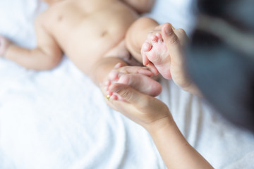 Obraz na płótnie Canvas Baby foot massage by mom hand after shower