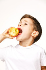 Little boy is eating apple studio shot 