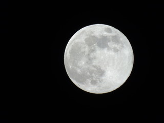 Genova, Italy - 03/20/2019: An amazing photography of the full moon over the city of Genova by night with a great clear sky in background and some stars