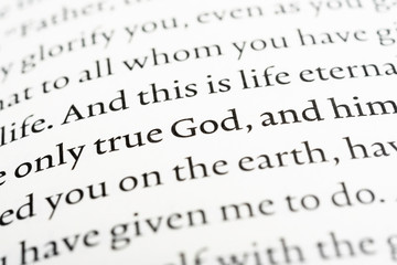 A macro shot of a page portion of the biblical text with selective focus on the word "God."