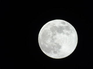 Genova, Italy - 03/20/2019: An amazing photography of the full moon over the city of Genova by night with a great clear sky in background and some stars