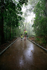 Mother and child walking in a forest in the rain