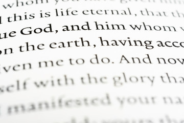 A macro shot of a page portion of the biblical text with selective focus on the word "God."