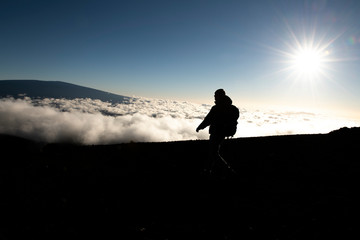 A hiking Tourist admiring breathtaking view of Mauna kea volcano on the Big Island of Hawaii.