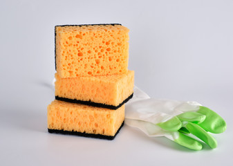 stack of yellow kitchen sponges for washing dishes and gloves