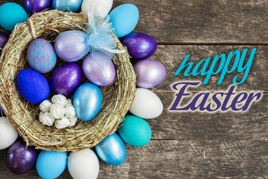 different shades of blue colored Easter eggs in nest on wooden background, selective focus image. Happy Easter card.