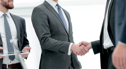 Business associates shaking hands in office