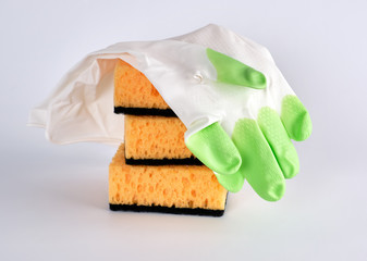 stack of yellow kitchen sponges for washing dishes and gloves
