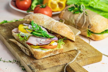 Sandwich with ham, tomato, cheese, pepper, onion and salad