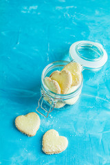 Fototapeta na wymiar Heart shaped cookies with coconut chips in glass jar