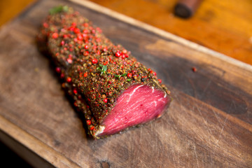 Raw beef marinated in spices. Fresh beefsteak in marinade of pepper and herbs