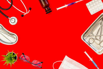 Medicine help with drugs frame on work desk of doctor red background top view mock up